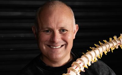 Darren, lead therapist, holding a model spine